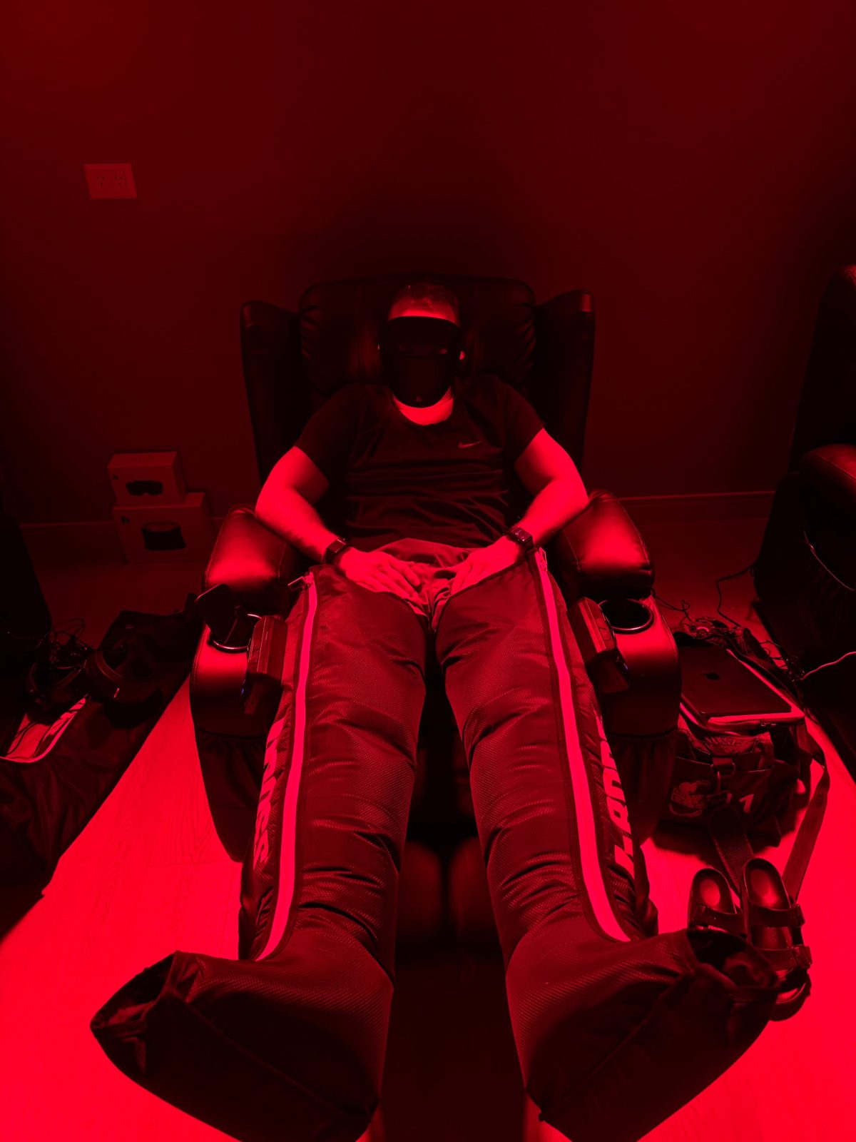 Cliente con botas de compresión y máscara de luz roja en el sillón de Sana
