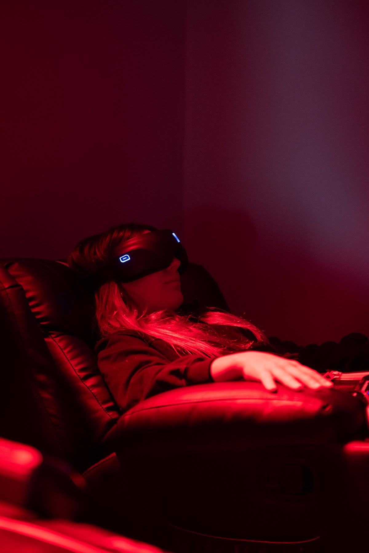 Clienta con máscara de luz roja en el sillón de recuperación